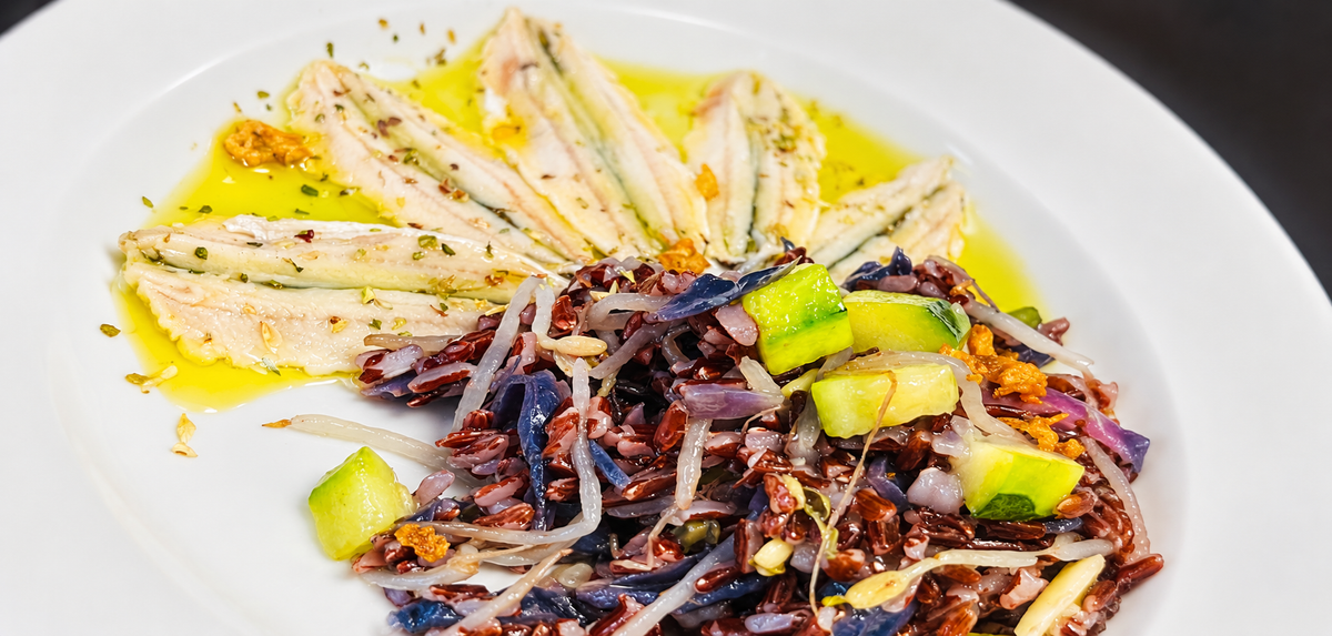 Boquerones en vinagre con arroz rojo integral, col lombarda, brotes y calabacín.