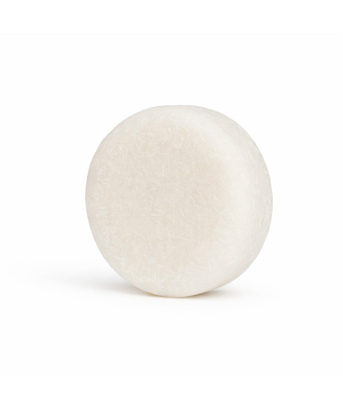 Champú sólido fortificante anticaída de color blanco, presentado sobre una superficie blanca.